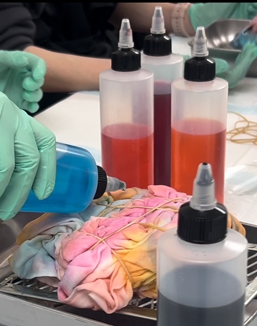 An instructor leading a hands-on tie-dye workshop at Altered Course Venue