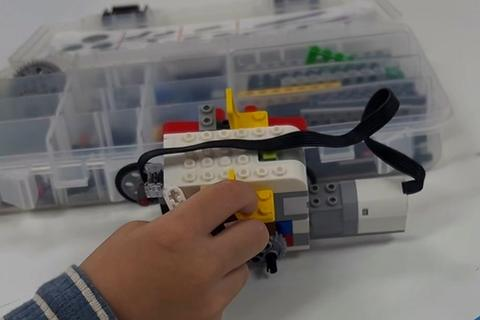 A child building a robot car with LEGO bricks at a Brick Builder birthday party